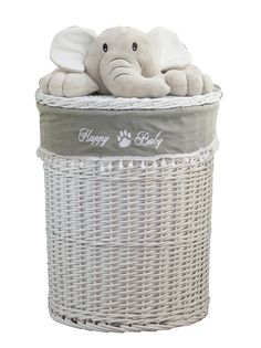 an elephant stuffed animal laying on top of a white wicker basket with the words happy baby written on it