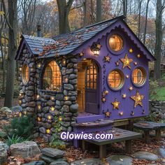 a small purple house with stars on the roof and windows is lit up by lights