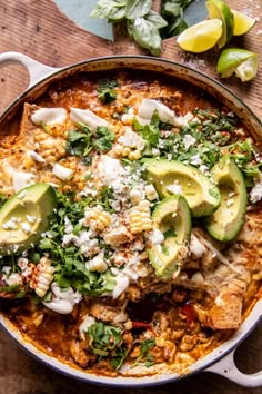 a large pot filled with chicken and avocado on top of a wooden table