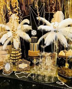 a table topped with lots of different types of cakes and desserts covered in white feathers