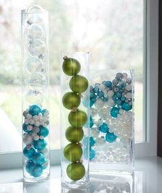 two vases with ornaments in them sitting on a window sill