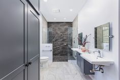 a bathroom with two sinks, a toilet and a walk - in shower next to each other