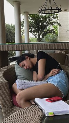 a woman laying on top of a couch next to a table