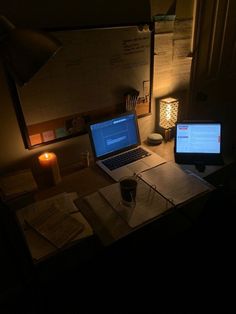 a laptop computer sitting on top of a wooden desk next to a desktop computer monitor