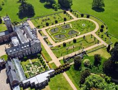 an aerial view of a large building in the middle of a lush green field