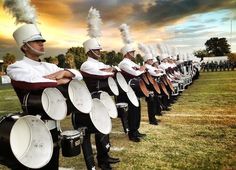 a marching band is lined up on the field with their instruments in front of them