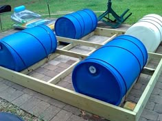 several large blue barrels sitting on top of a wooden pallet