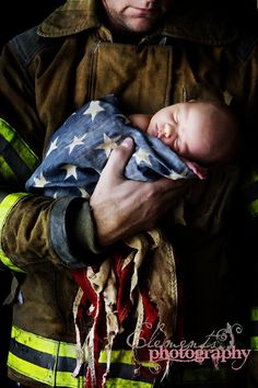 a firefighter holding a baby in his arms