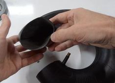 two hands are holding a black object near a sink faucet and soap dispenser