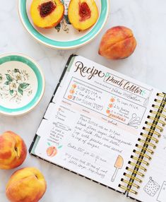 a recipe book with peaches next to it on a marble counter top and plates