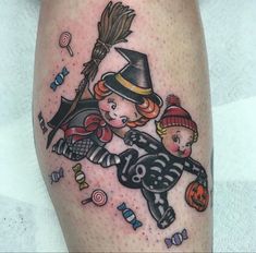 a small tattoo on the leg of a child wearing a witch hat and holding a broom