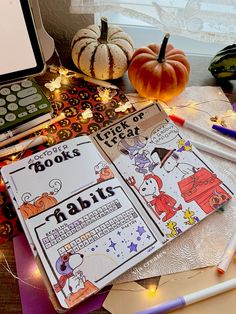 an open book sitting on top of a table next to a pumpkin and other items