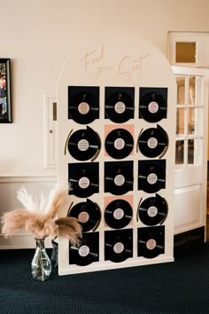 a record display with an ostrich feather on top and some vinyl records in the bottom