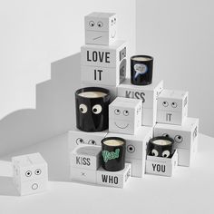 several black cups with googly eyes are stacked on top of each other in boxes