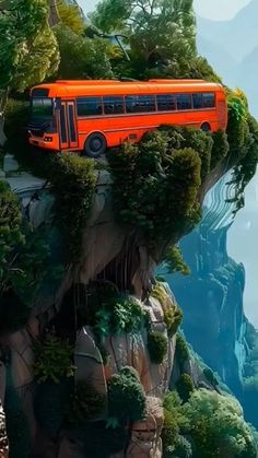 an orange bus is parked on top of a mountain with trees and bushes in the foreground