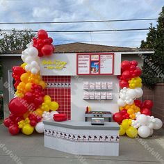 a mcdonald's stand with balloons on the front and side wall, along with an ice cream kiosk