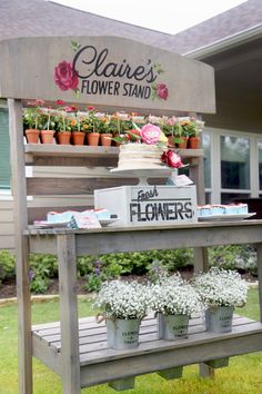 an outdoor flower stand with flowers on it