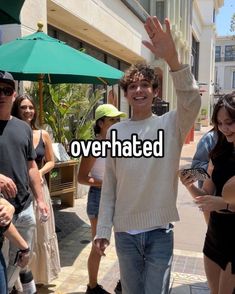 a young man waves to the crowd while holding his hand up