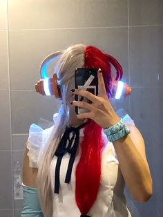 a woman taking a selfie in front of a bathroom mirror with headphones on