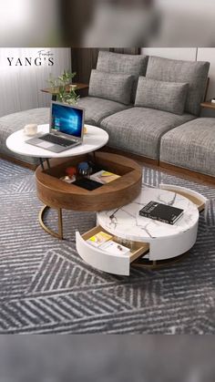 a coffee table with a laptop on it in front of a couch and rugs