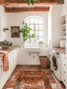 a washer and dryer in a small room with a rug on the floor