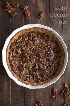 a pecan pie in a white dish on a wooden table