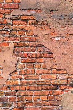 an old brick wall with peeling paint and chipping off the top part is shown