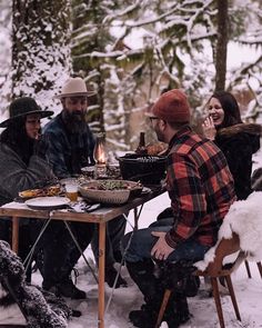 a group of people sitting around a table in the snow