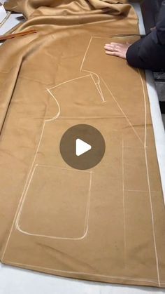 a person is making a dress out of brown paper