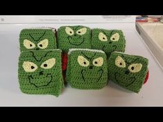 green crocheted coasters with faces on them sitting on top of a counter