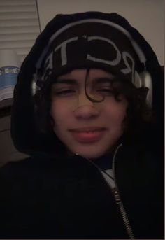 a young man wearing headphones and a hoodie