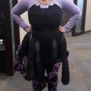 a woman standing in front of a mirror with her hands on her hips wearing black and purple