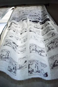 an unmade bed with comics printed on it