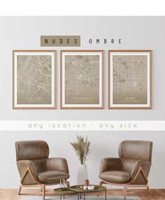 three framed maps are hanging on the wall above two leather chairs and a coffee table