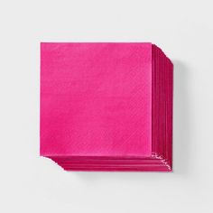 bright pink napkins stacked on top of each other in front of a white background