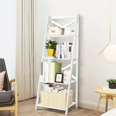 a living room with a white book shelf and chair next to a table filled with books