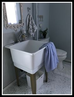 a white sink sitting under a bathroom mirror