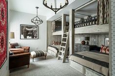 a room with bunk beds, couches and a ladder to the top of it