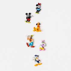 several mickey mouse pins sitting on top of a white surface