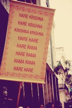 a group of people standing in front of a building with a sign that says har kishna