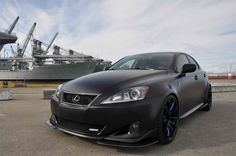 a black car parked in front of a large ship