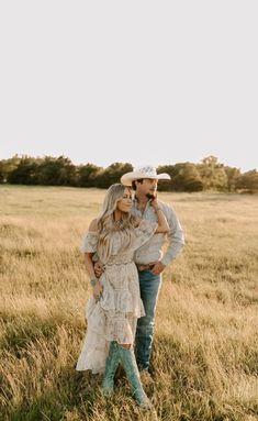 a man and woman standing in the middle of a field