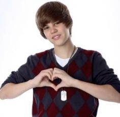 a young man making a heart with his hands and wearing a sweater shirt that says i love you