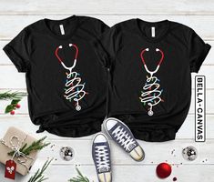 "Nurse Stethoscope Christmas Tree Shirt, Merry Christmas Nurse Tee Shirt, Xmas Health Tree Tshirt Gift For Nurse, Doctor Christmas Shirt Share the holiday spirit with our Nurse Stethoscope Christmas Tree Shirt! Celebrate the season with this Merry Christmas Nurse Tee Shirt, featuring a stethoscope forming a festive Christmas tree. It's not just a shirt; it's a heartwarming Xmas Health Tree Tshirt Gift For Nurse, perfect for healthcare professionals. Let doctors join in the fun with this Doctor Christmas Shirt. Make it a healthy and festive season with this thoughtful gift. 🎄❤️🏥 #NurseLife Hi!  Welcome. It's great to see you here! ☺️ Our shirts are clean, high quality and soft. It is prepared quickly by our boutique.  Ironing and shipped.  Enjoy your shopping! It is a pleasure for us to h Christmas Shirt For Doctor Office, Womens Christmas Shirts Nurse, Tree Tshirt, Nurse Stethoscope, Trendy Shirt Designs, Christmas Party Shirts, Nurse Christmas, Christmas Tree Shirt, Cute Shirt Designs