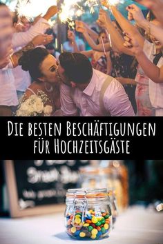 a man and woman kissing in front of a group of people holding sparklers with the words die besten beschaftigungen fur hochzetsgaste