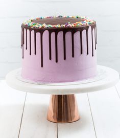 a pink cake with chocolate icing and sprinkles