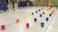 several children are playing with plastic cups on the floor