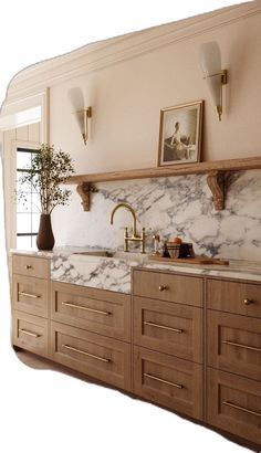 a kitchen with marble counter tops and wooden cabinets, gold faucets and brass pulls