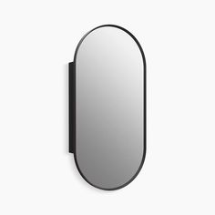 an oval mirror mounted on the wall next to a black frame with a white background