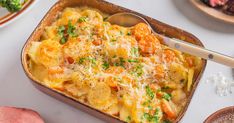 a casserole dish with carrots, cheese and parmesan on the side